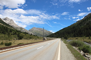 Berninabahn, Passstraße und Berninabach, im Hintergrund v. l. n. r.: Piz Alv und Piz Lagalb